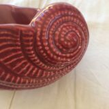 Empty red ceramic snail shaped pouch