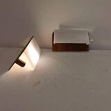A pair of teak wood wall lamps with plastic shade.