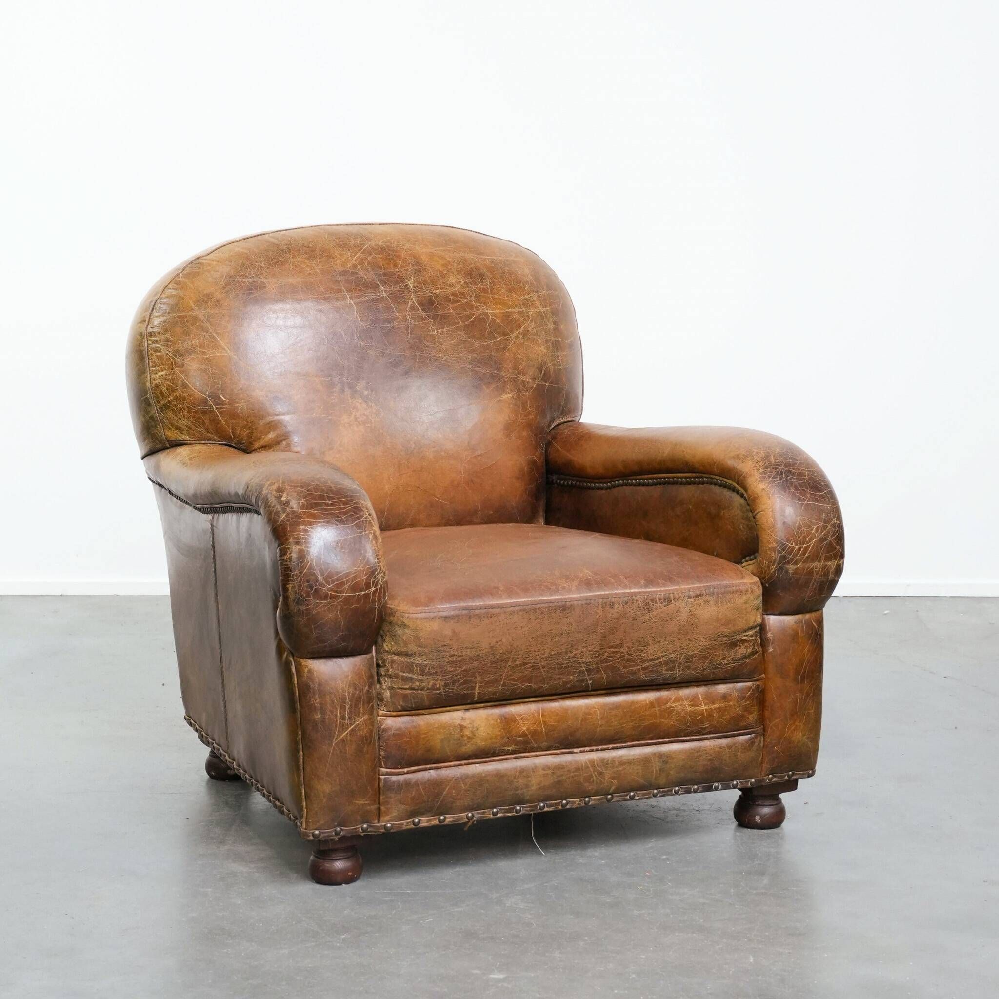 Charming and comfortable vintage armchair in grained cowhide leather with character