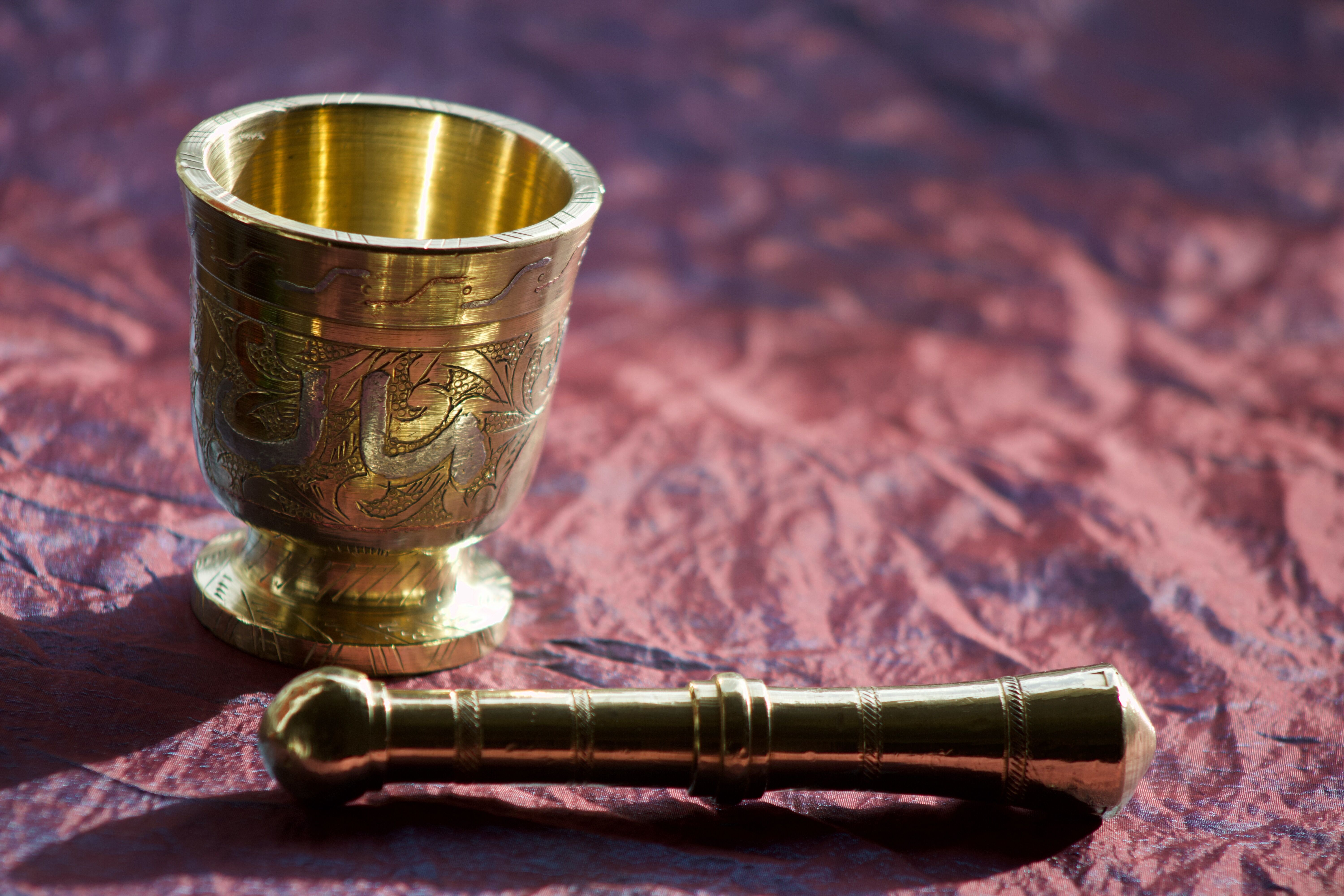 Mortar and its brass pestle with oriental gold and silver motifs