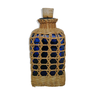 Blue bottle covered with wicker