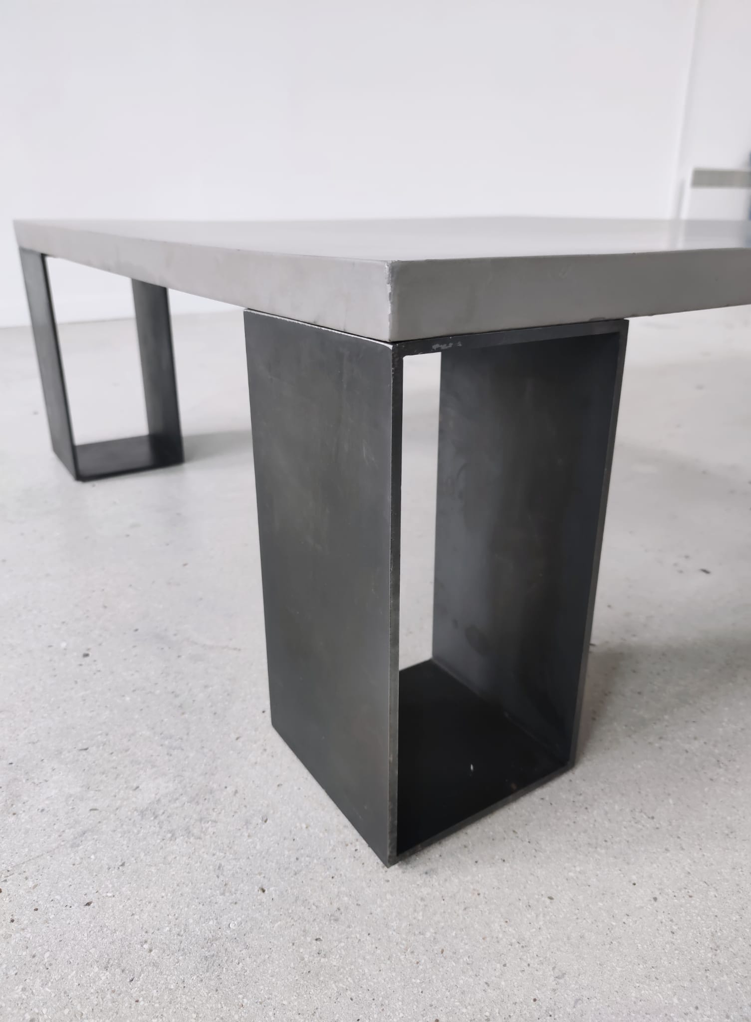 Table basse minimaliste en béton ciré et acier massif 1m20x1m20