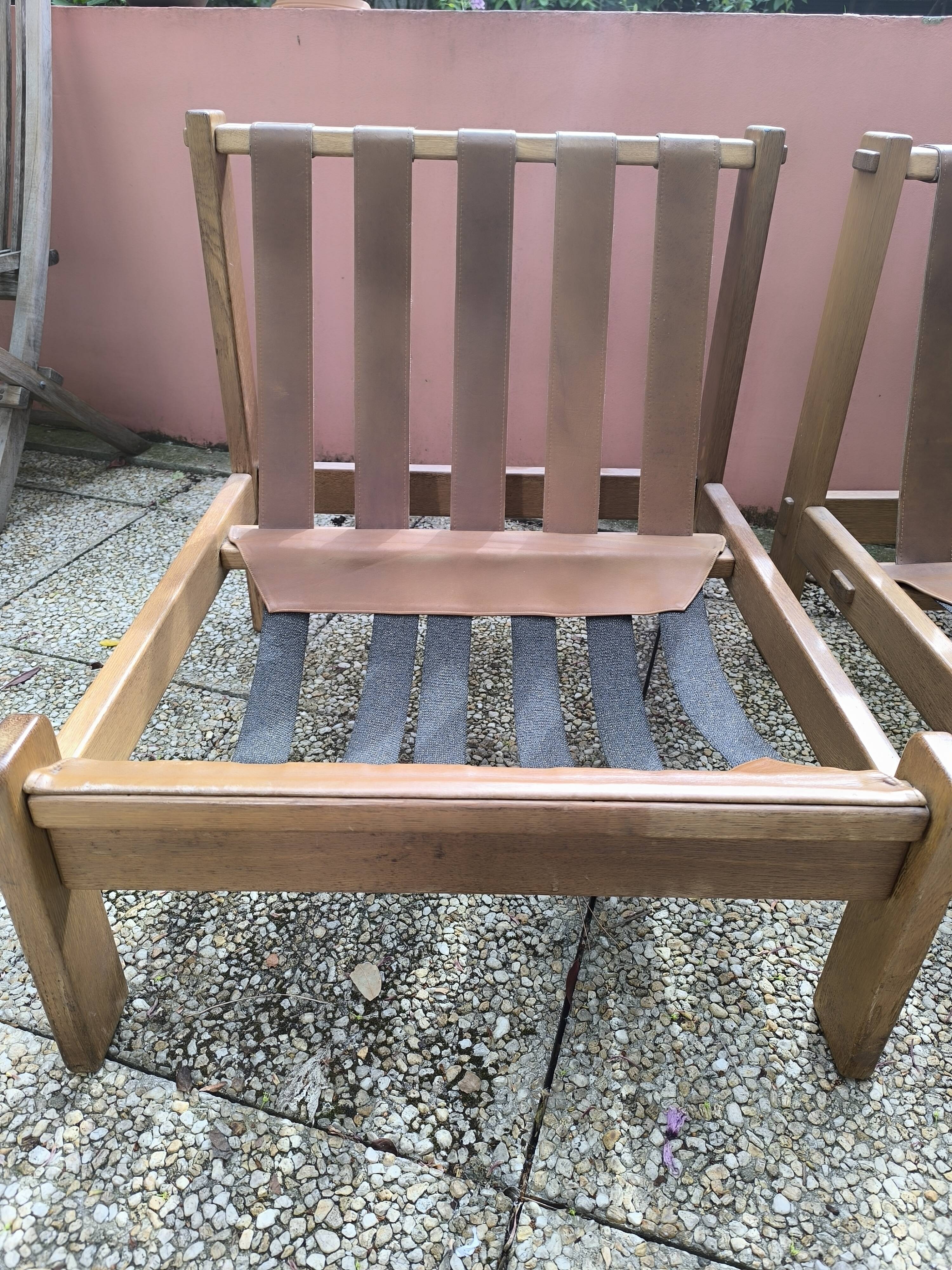 Pair of solid wood and leather lounge chairs, European work, circa 1970.
