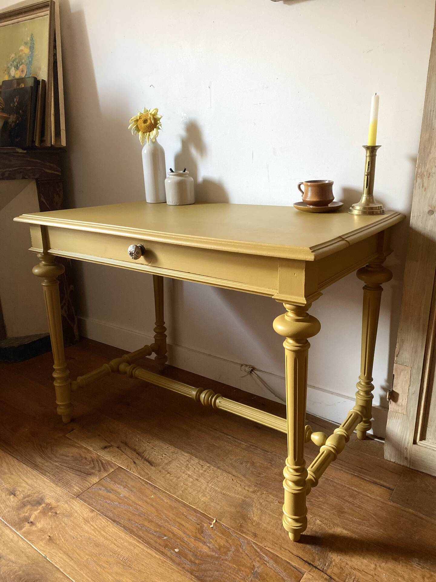 Desk table from the late 19th century, painted mustard, with turned stretcher.