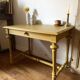 Desk table from the late 19th century, painted mustard, with turned stretcher.