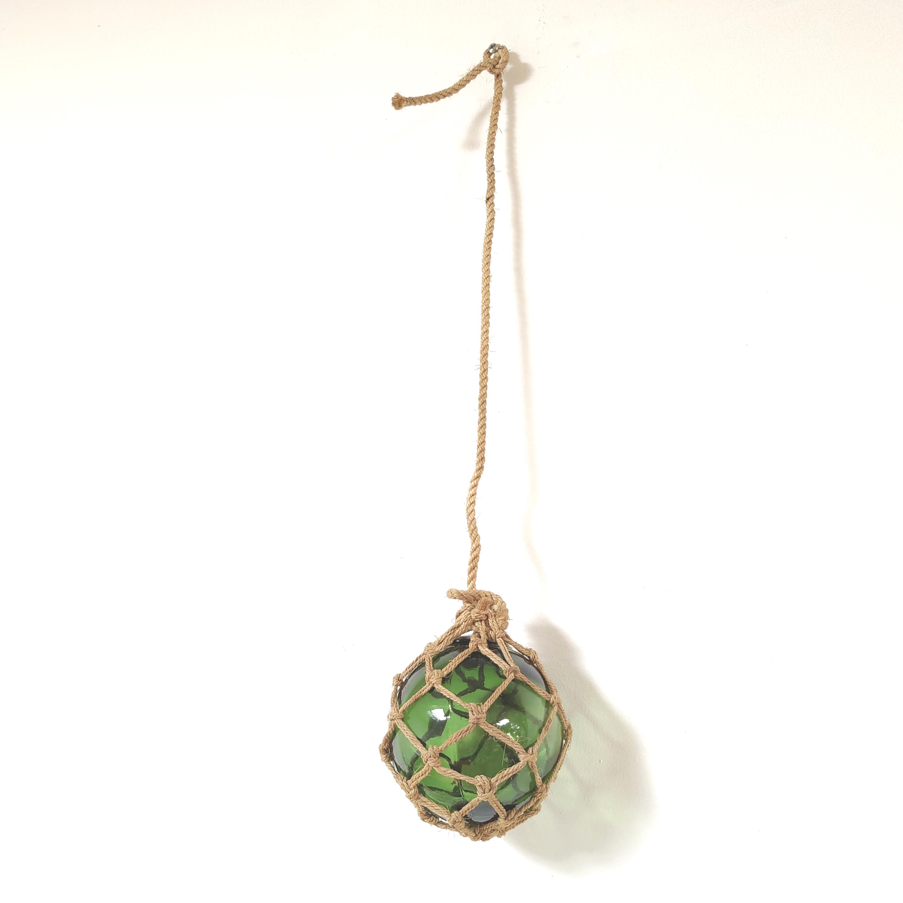 Green ball marine float in glass and rope