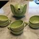 Handcrafted ceramic tea set with animal decoration.
