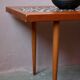 1970s coffee table with a tapered teak base and ceramic mosaic.