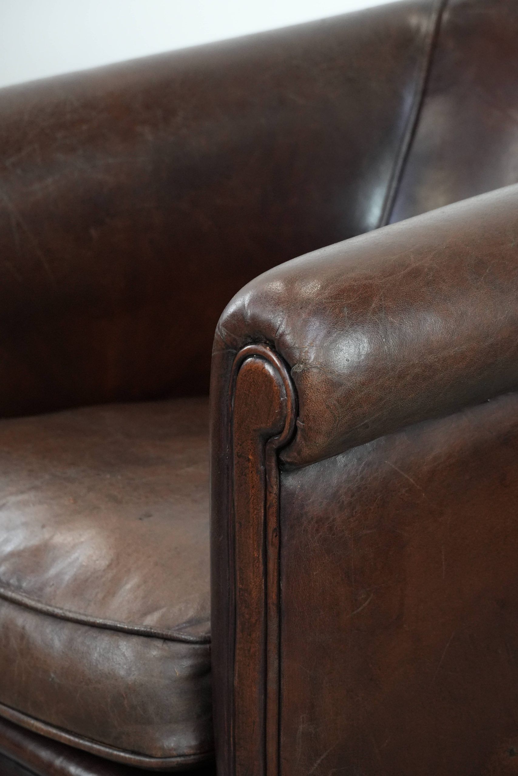 Stylish and sturdy dark brown club armchair made of sheepskin leather