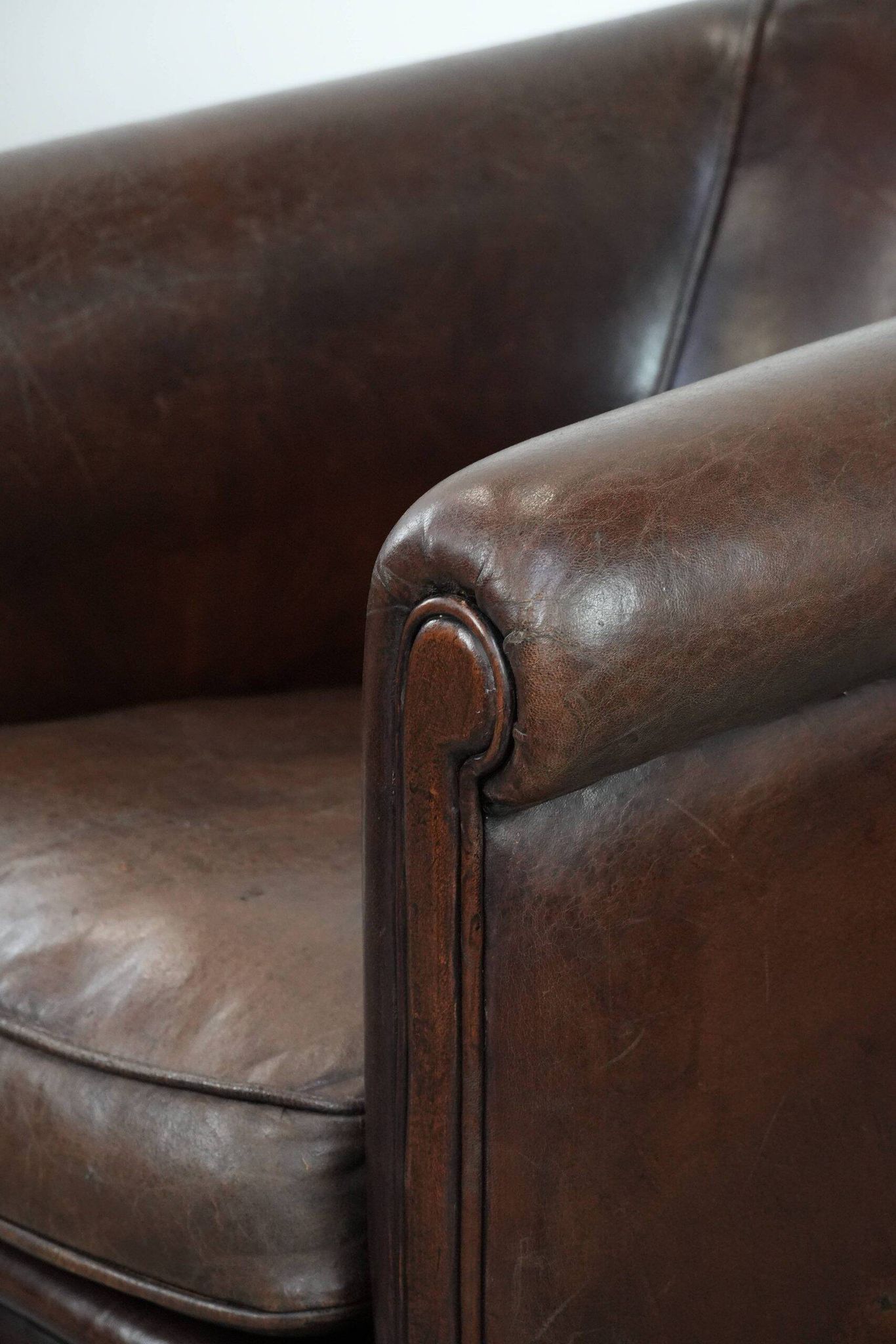 Stylish and sturdy dark brown club armchair made of sheepskin leather