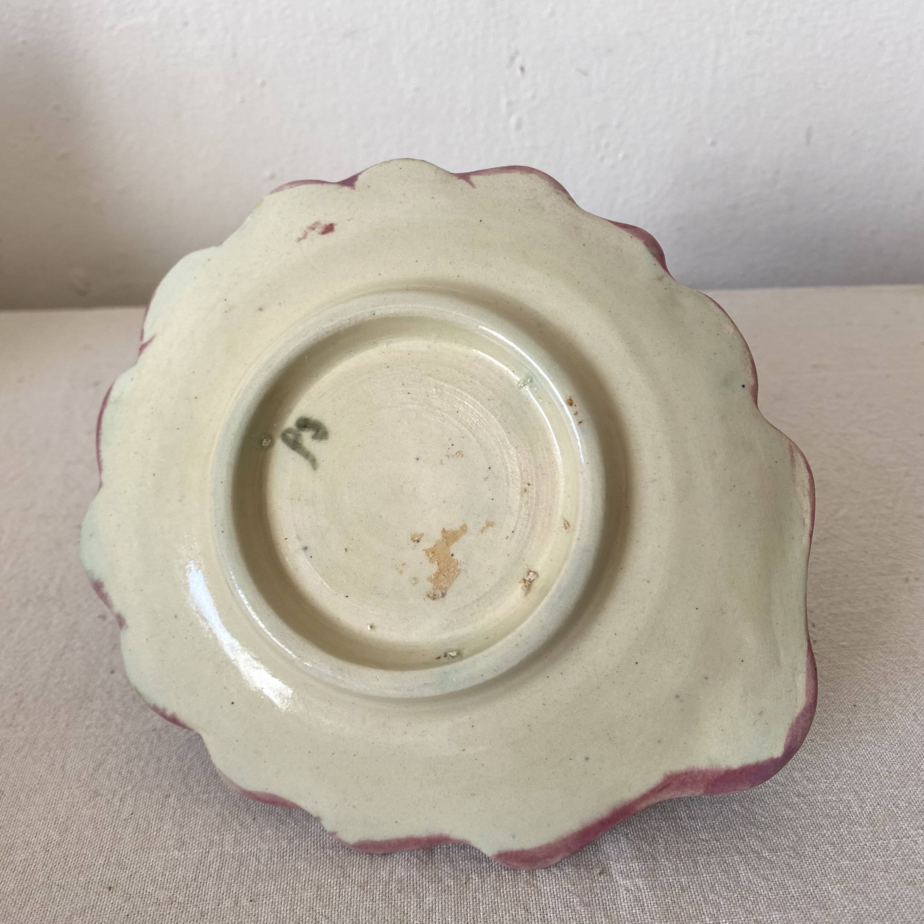 Antique slip candlestick depicting a flower