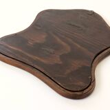 Antique wall mirror in carved wood with a wavy shape and a golden trim.