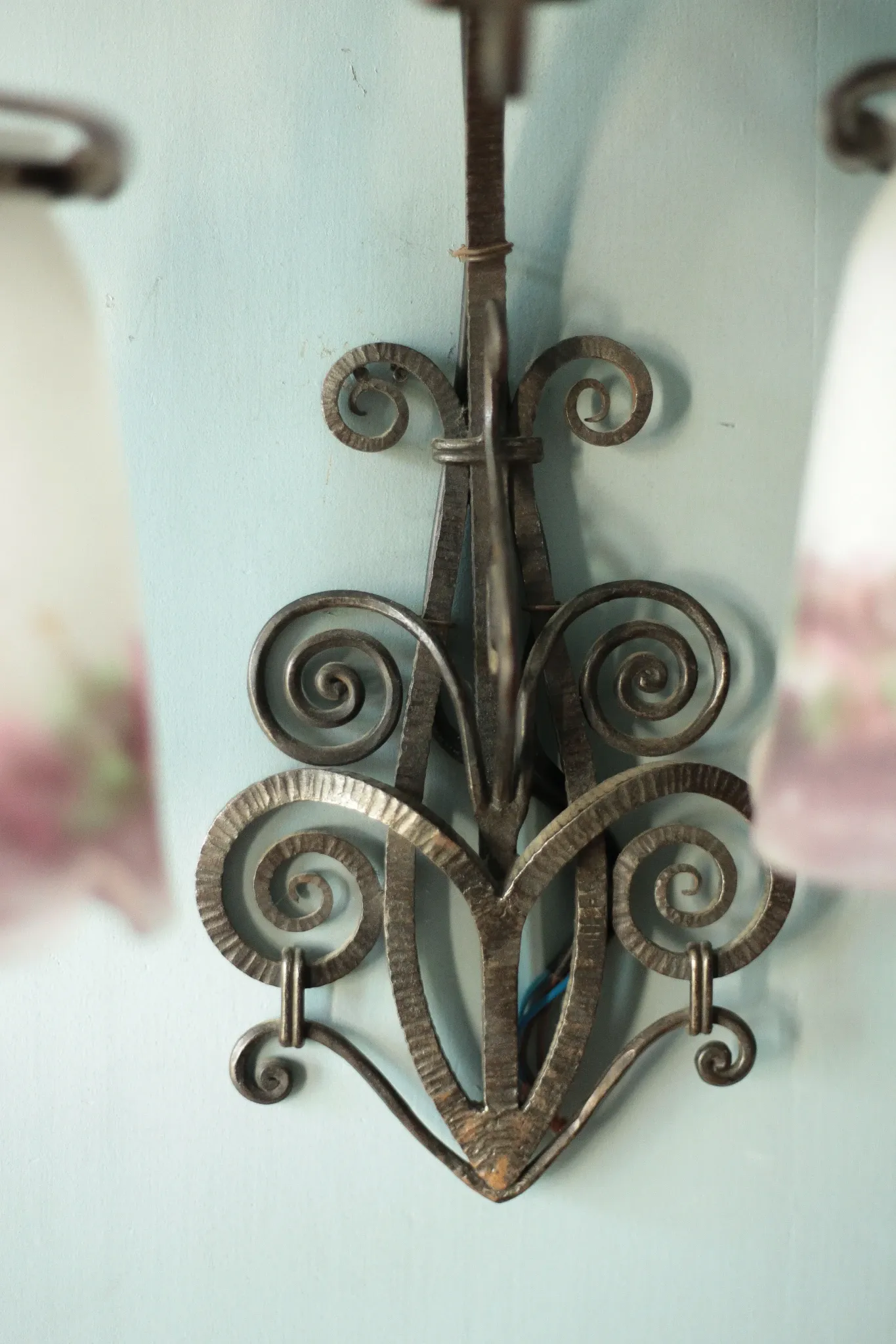 Wall lamp in wrought iron with a pink tulip glass globe by Muller glassworks.