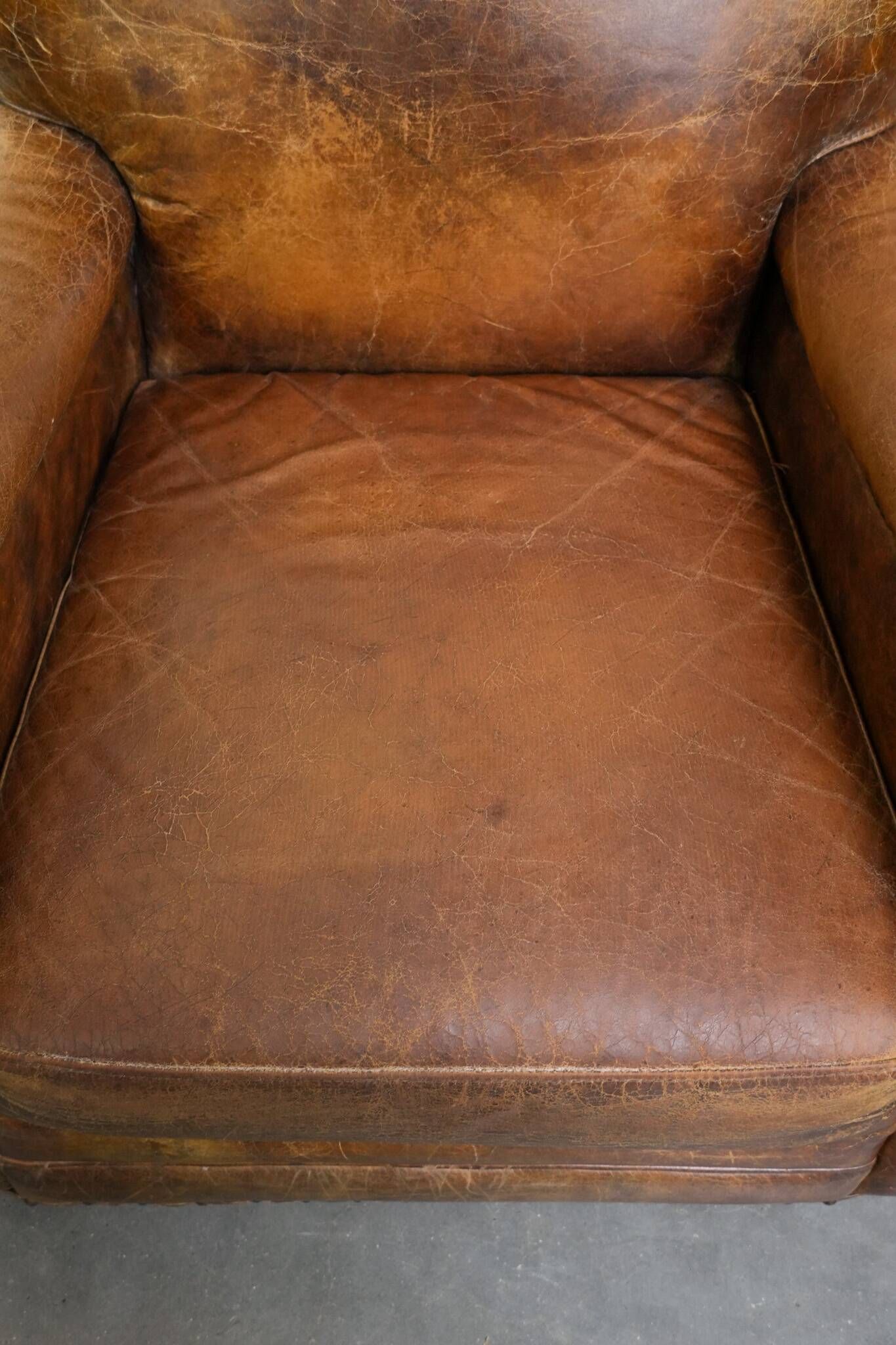 Charming and comfortable vintage armchair in grained cowhide leather with character