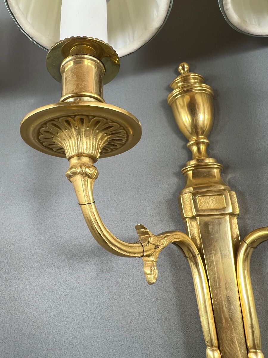 Set of three Louis XVI style wall sconces in gilded bronze, 20th century.