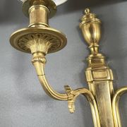 Set of three Louis XVI style wall sconces in gilded bronze, 20th century.