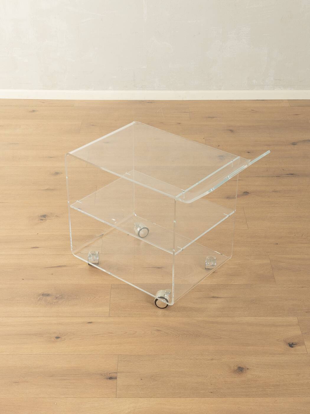 Wonderful side table from the 1960s, high-quality frame and shelf made of transparent acrylic with chrome-plated castors
