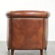 Sheepskin club armchair with a cognac colour finished with decorative nails