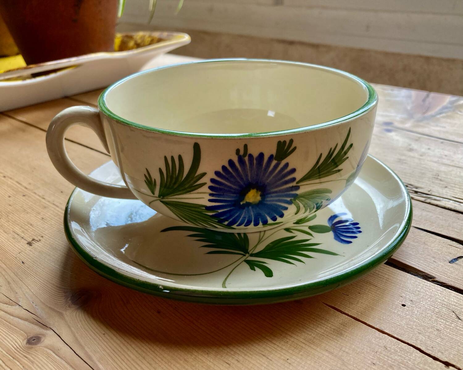 Large cup and saucer in the quimper earthenware style.