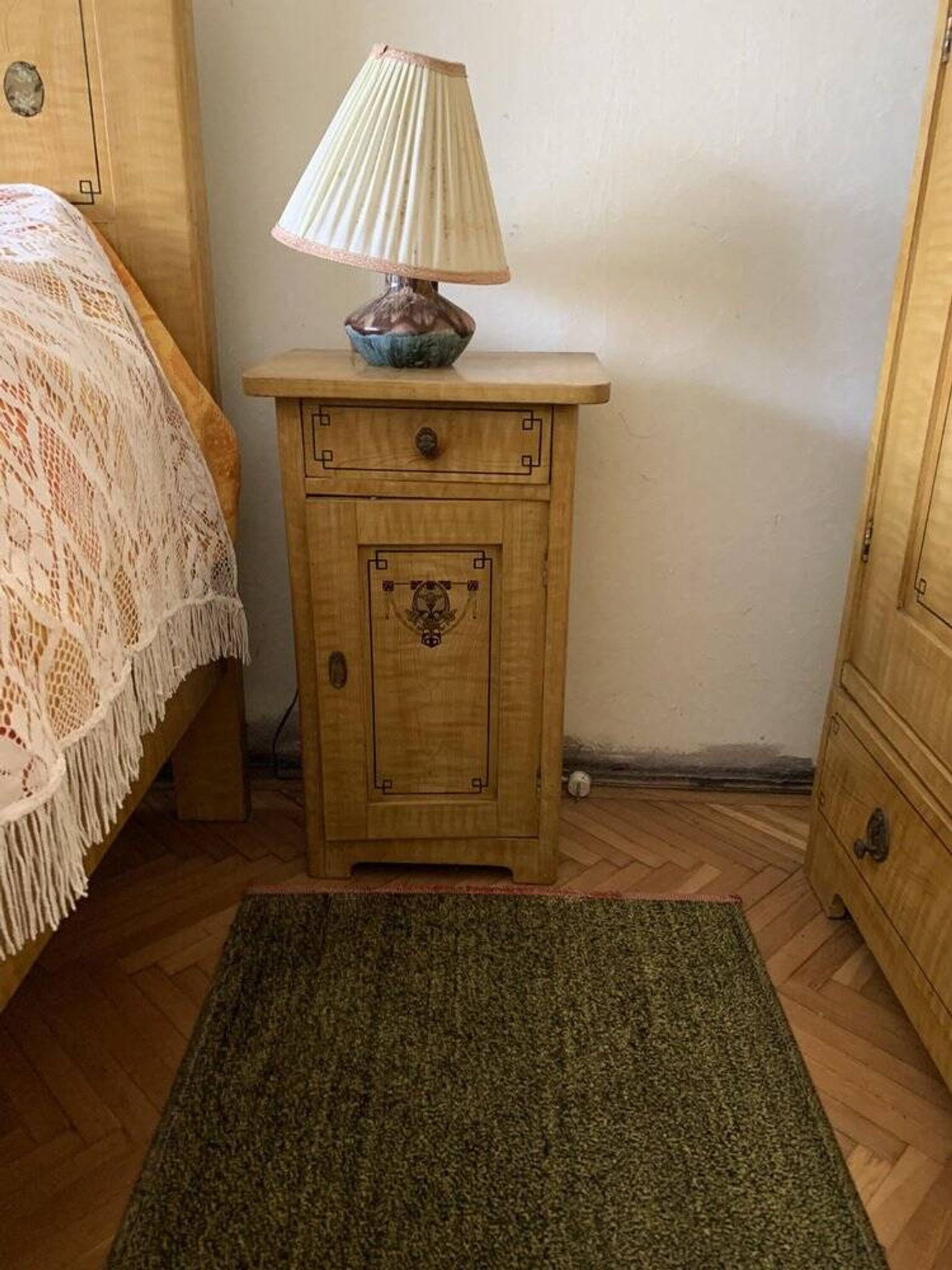 Vintage wooden bedside table painted brown, with a drawer and door, painted decoration from the 1890s.