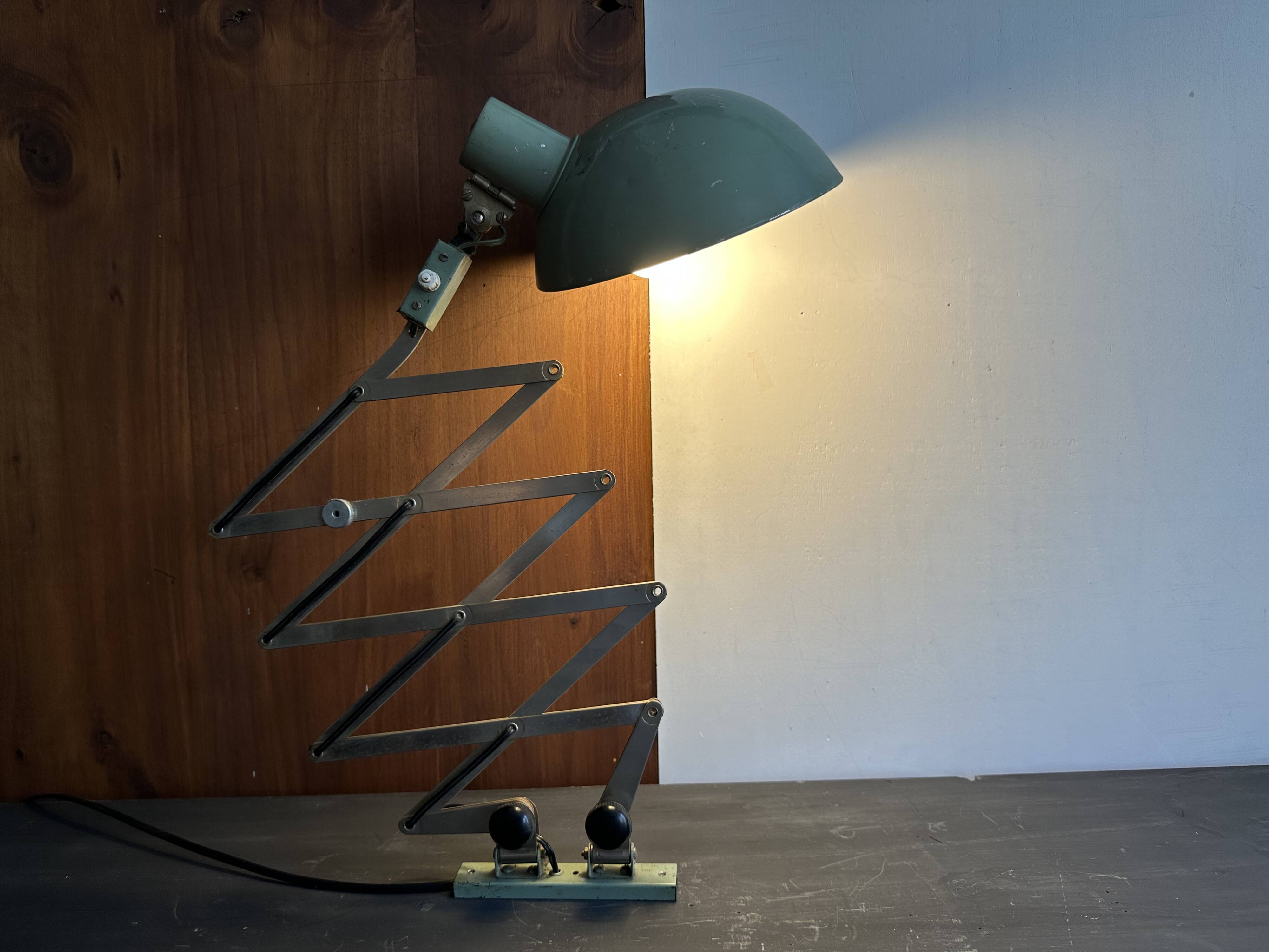 Old extendable accordion lamp in celadon green, workshop spirit.