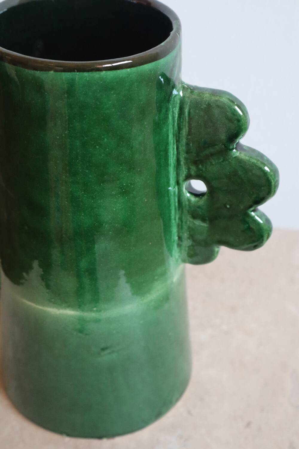 Handmade ceramic abstract vase with asymmetrical handles and fir green flowers