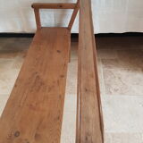 Church bench in fir tree with armrests