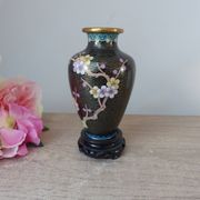 Small black cloisonné vase decorated with yellow and pink cherry blossoms, vase on wooden base
