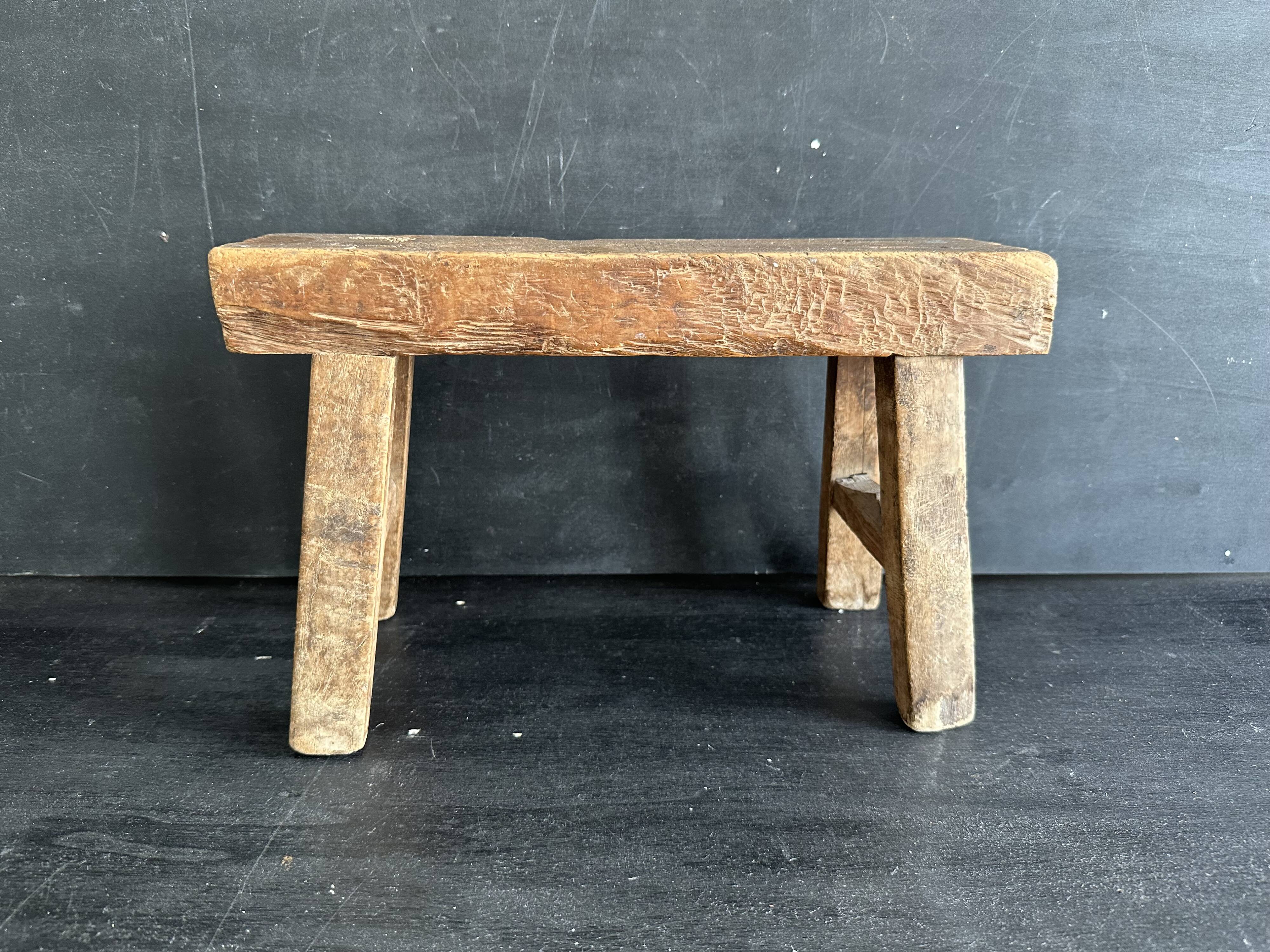 Ancient Chinese farm bench in patinated wood, small rustic stool.