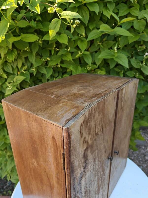 Small freestanding or wall-mounted wooden cabinet.