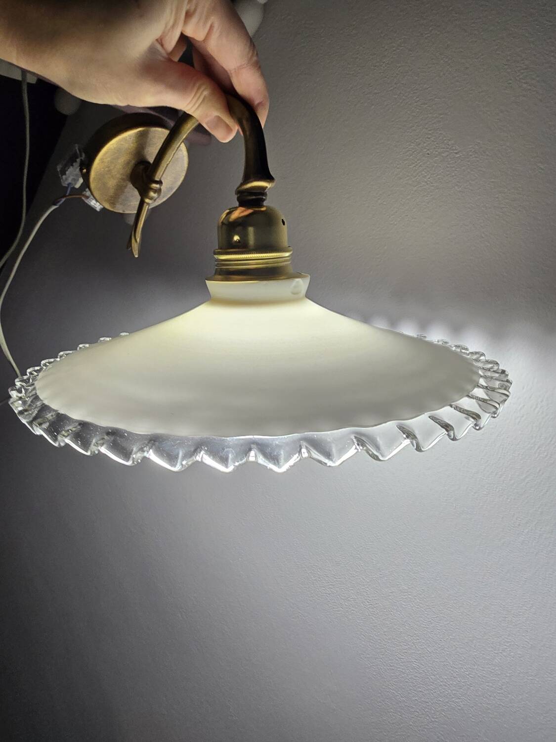 Wall sconces with scalloped opaline lampshades.