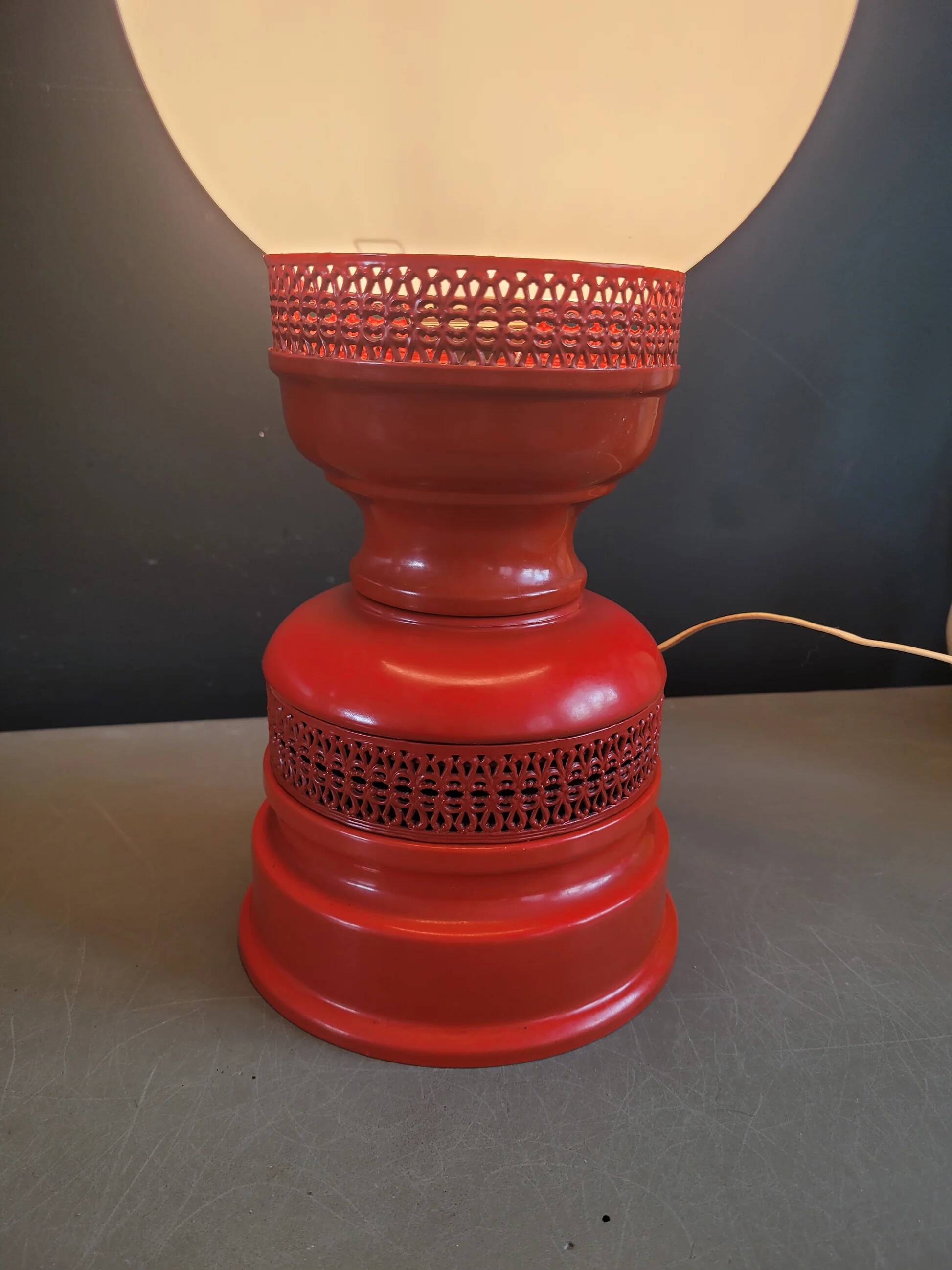 Vintage globe lamp with a metal base, perforated and lacquered in red.