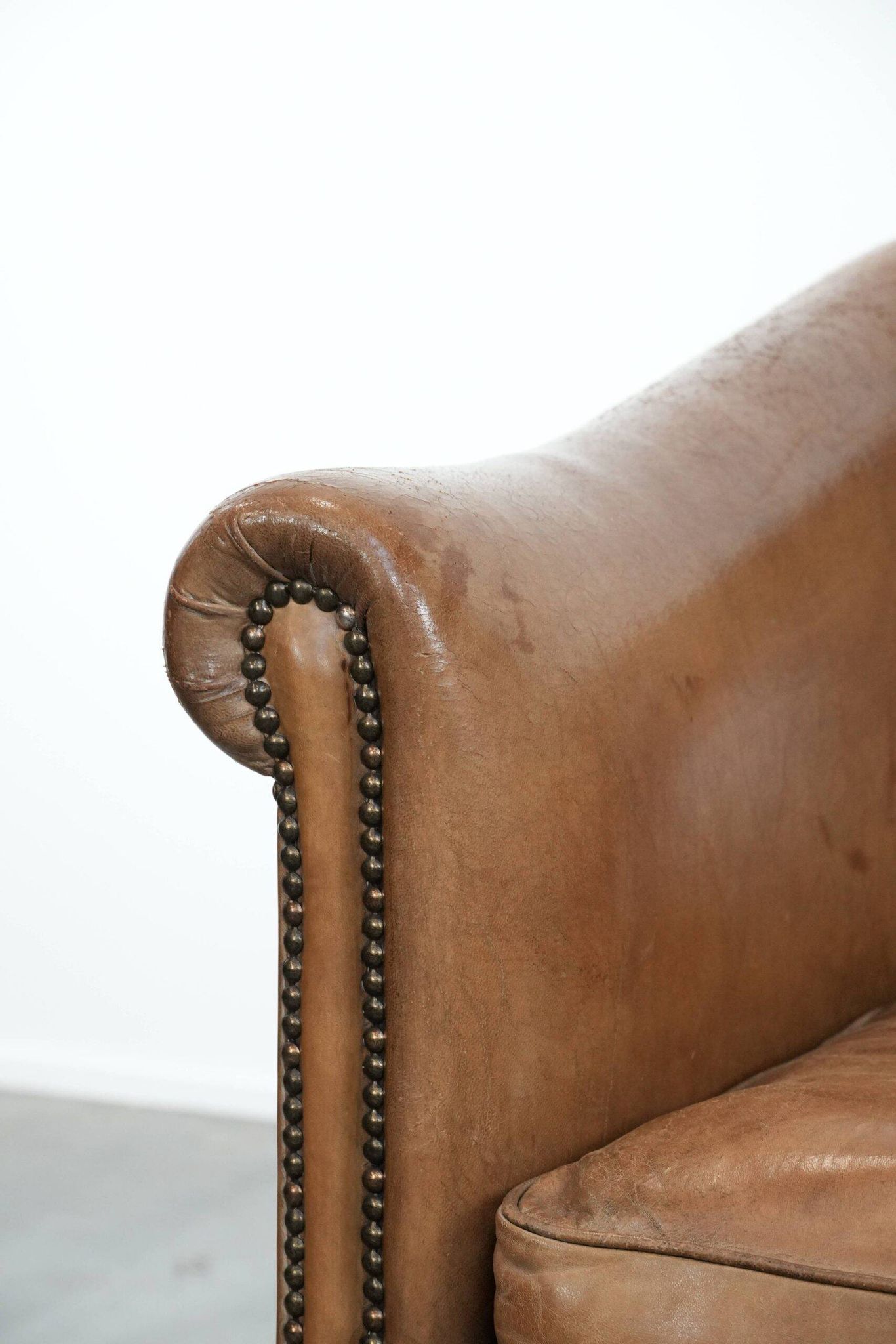 Characterful club chair made of sheepskin leather with light cognac colours