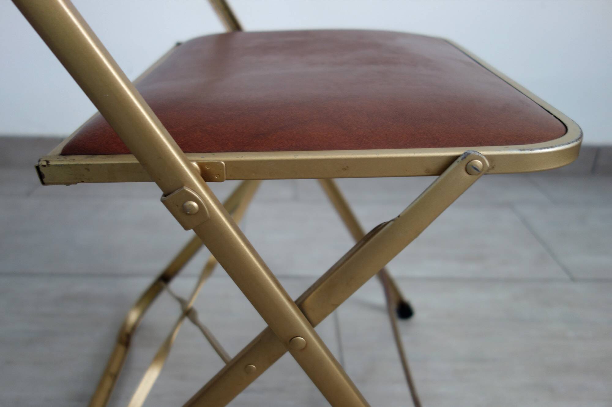 2 golden metal chairs with faux leather in the 60s/70s Opera style.