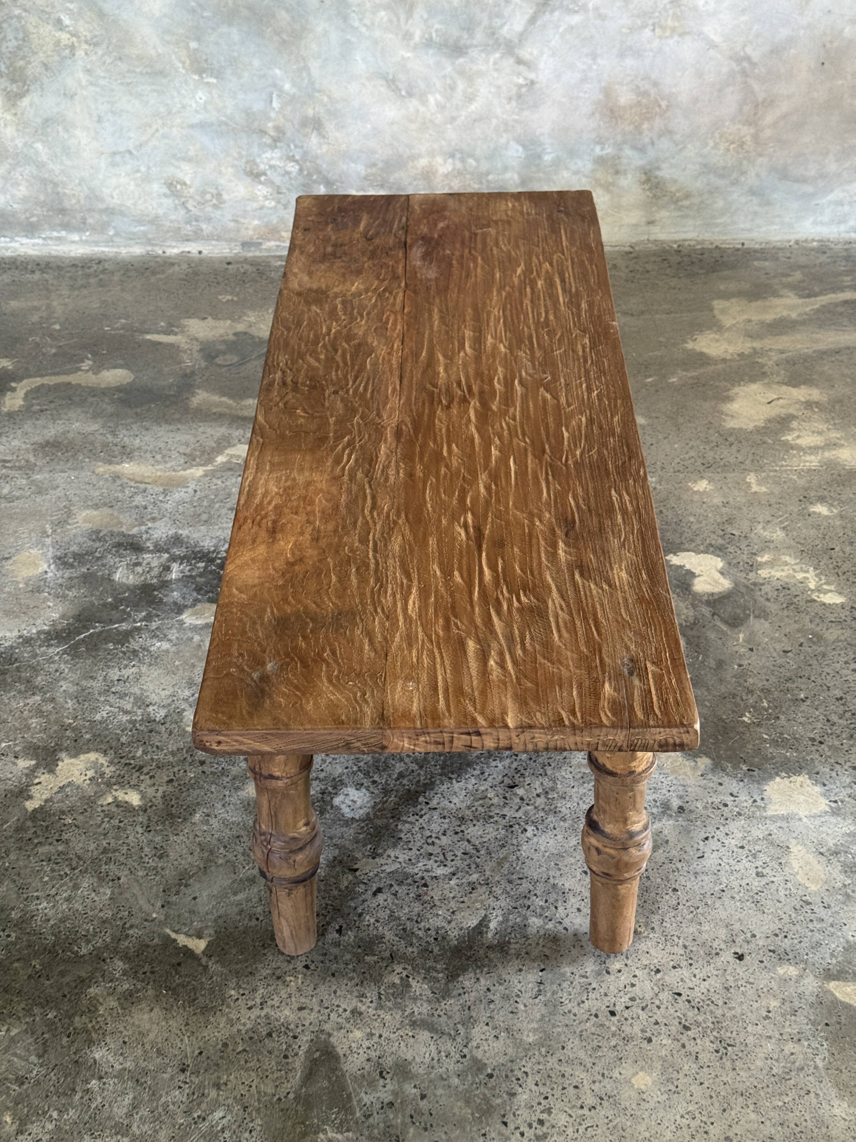 Brown Indonesian teak coffee table, with a border and cylindrical legs H40 L103.