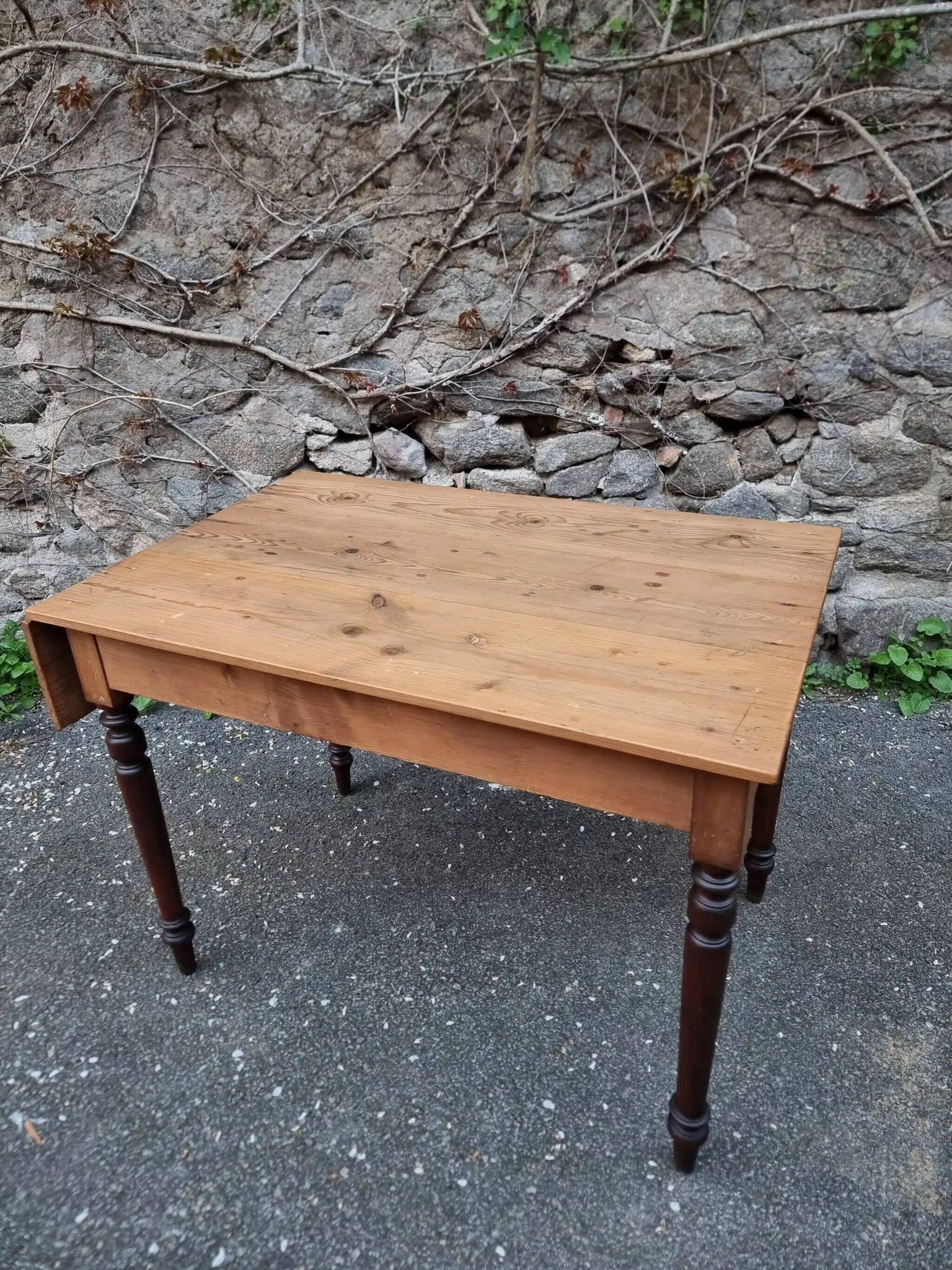 Vintage pine table with drop-leaf extension and turned beech legs, France, 1930s.