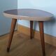 Tripod console table plant stand in the shape of a plectrum.