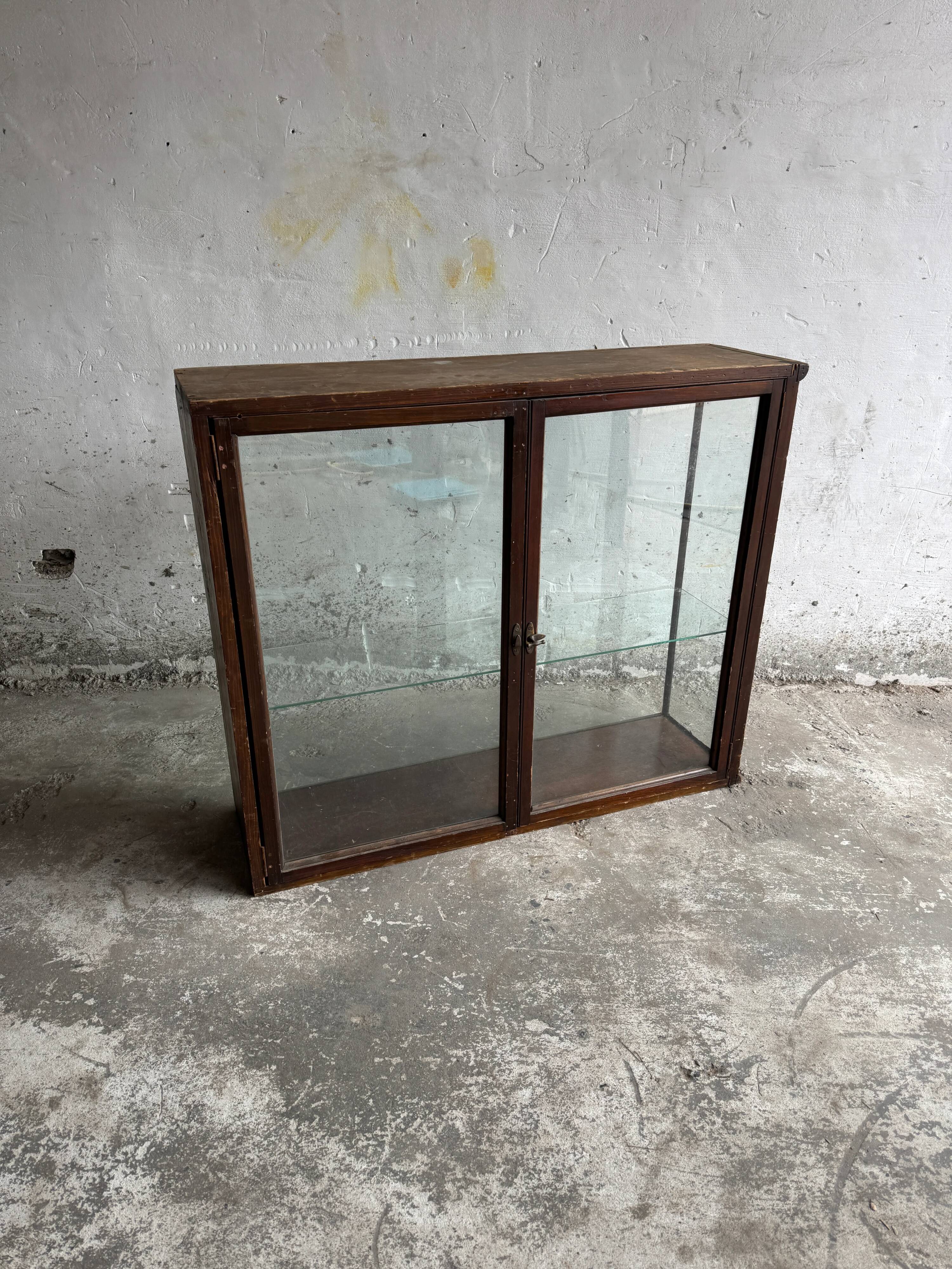 Dark-stained wood and glass vintage display cabinet — early 20th-century wall-mounted showcase