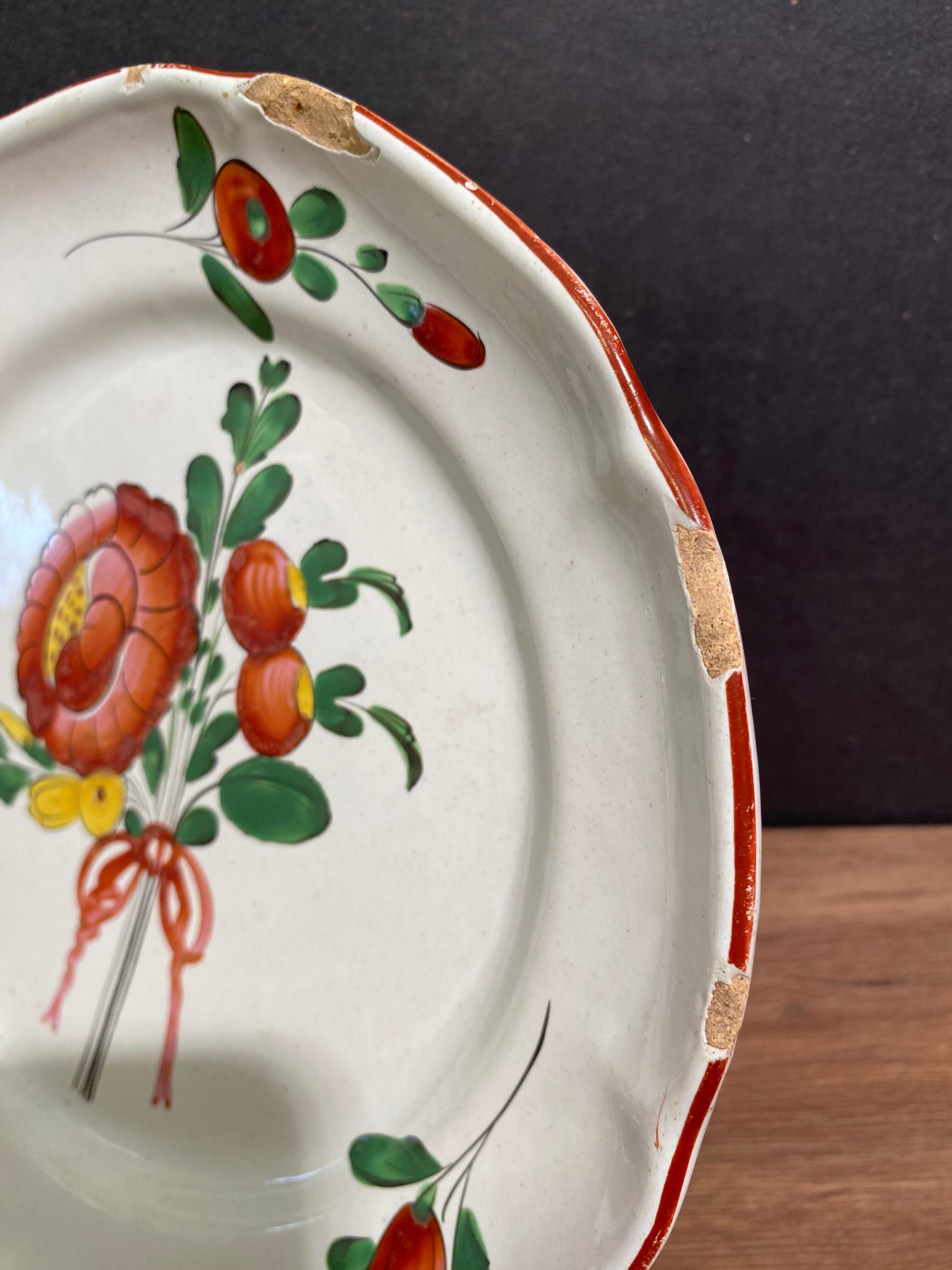 Assiette en faïence de l'Est XVIII-XIXe, décor floral enrubanné