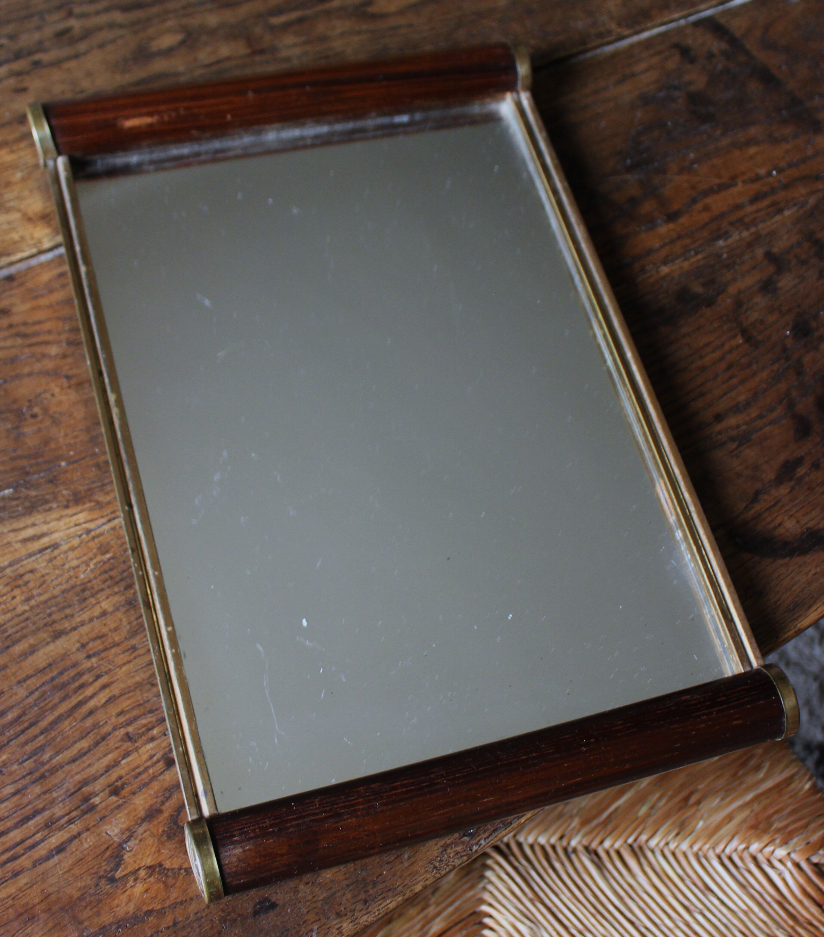 Rectangular mirror tray with wooden handles and gilding.