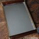 Rectangular mirror tray with wooden handles and gilding.