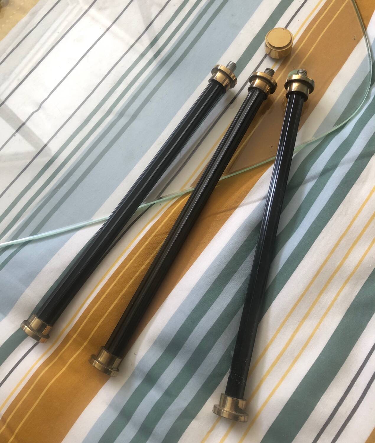 2 small side tables in glass and Bakelite with gold nuts from the 1960s.
