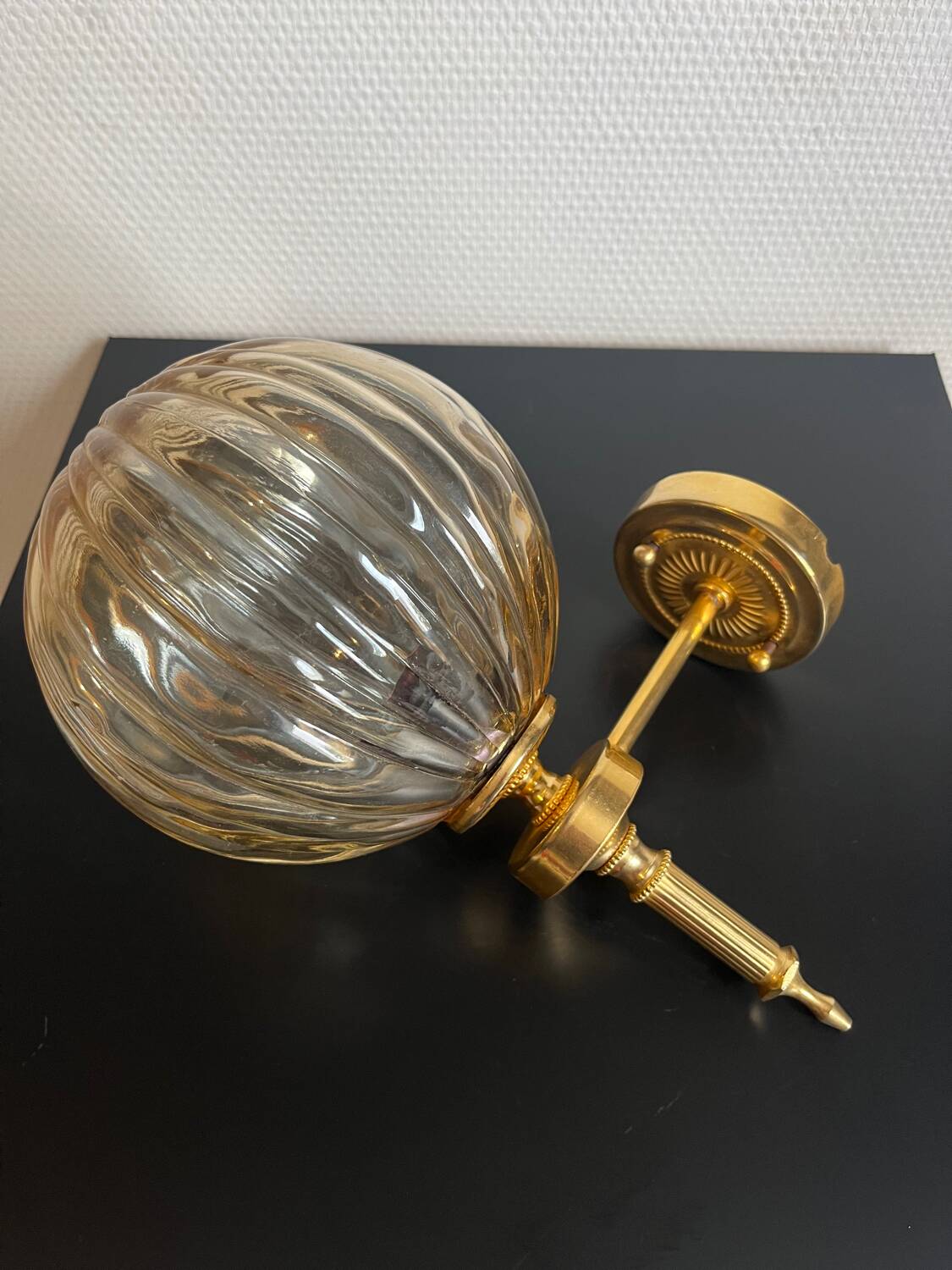 Brass wall light and bubbled glass globe