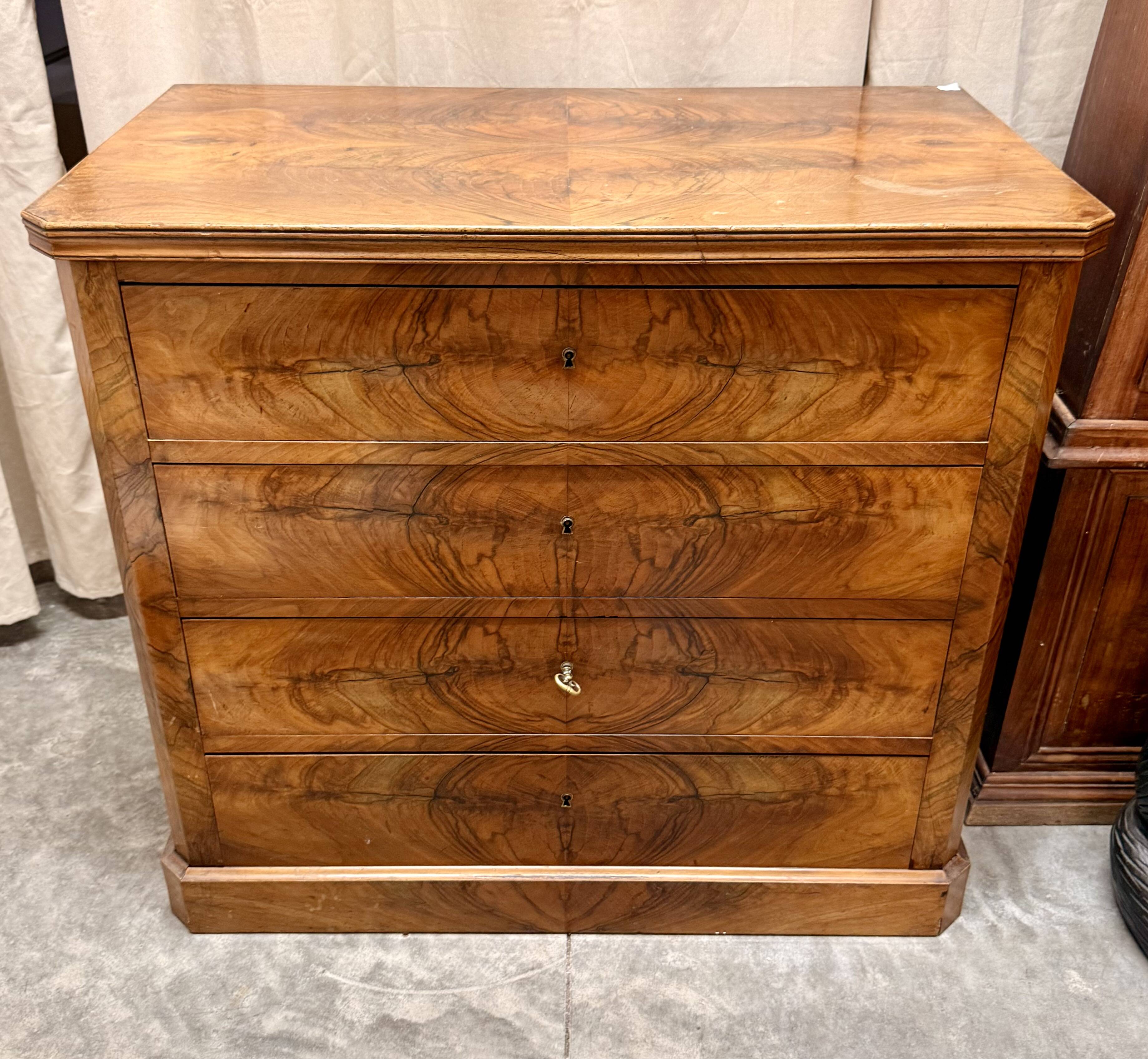 Antique English commode in flame walnut.
