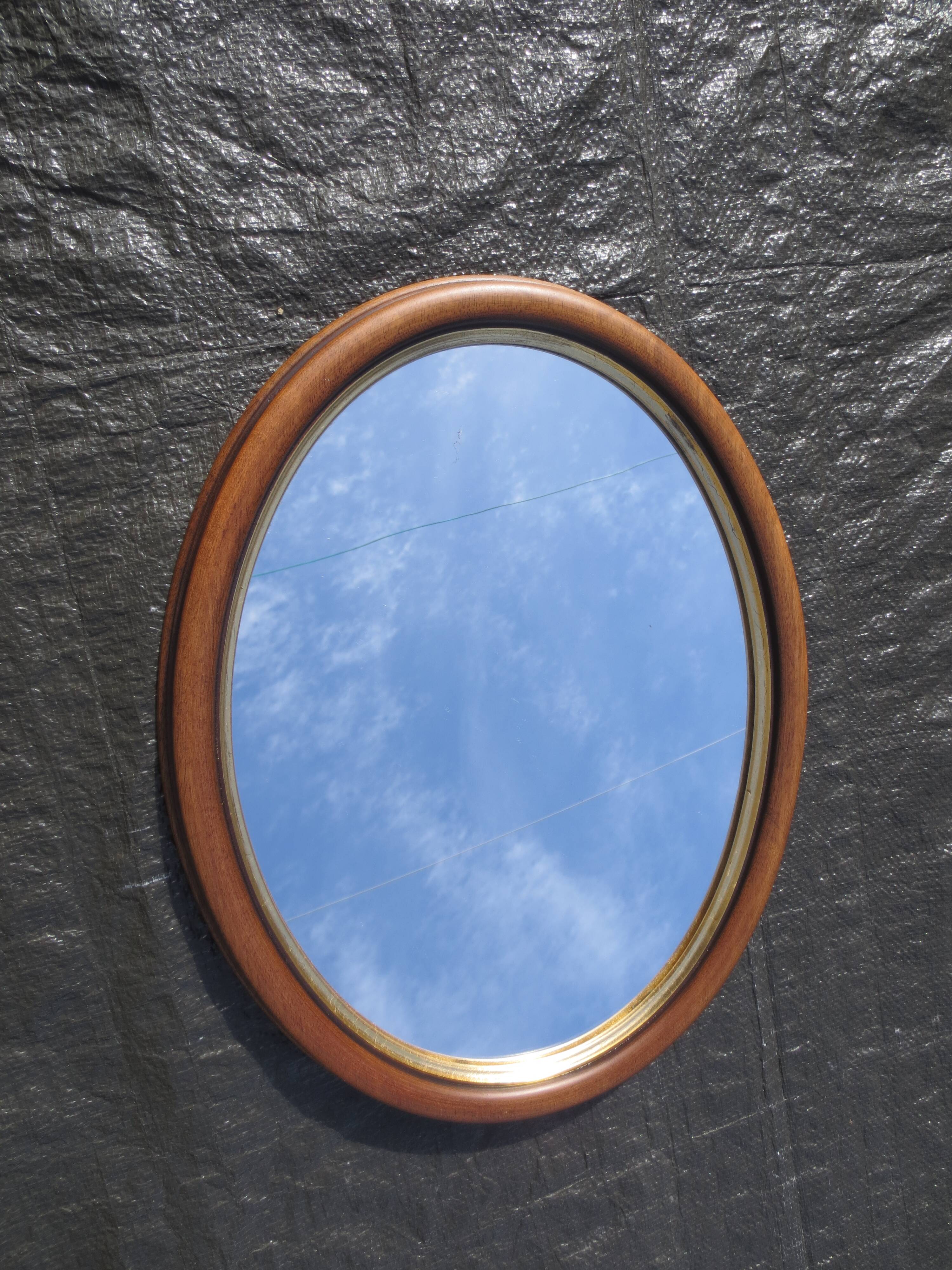 Old oval mirror, walnut wood tower, gilded border