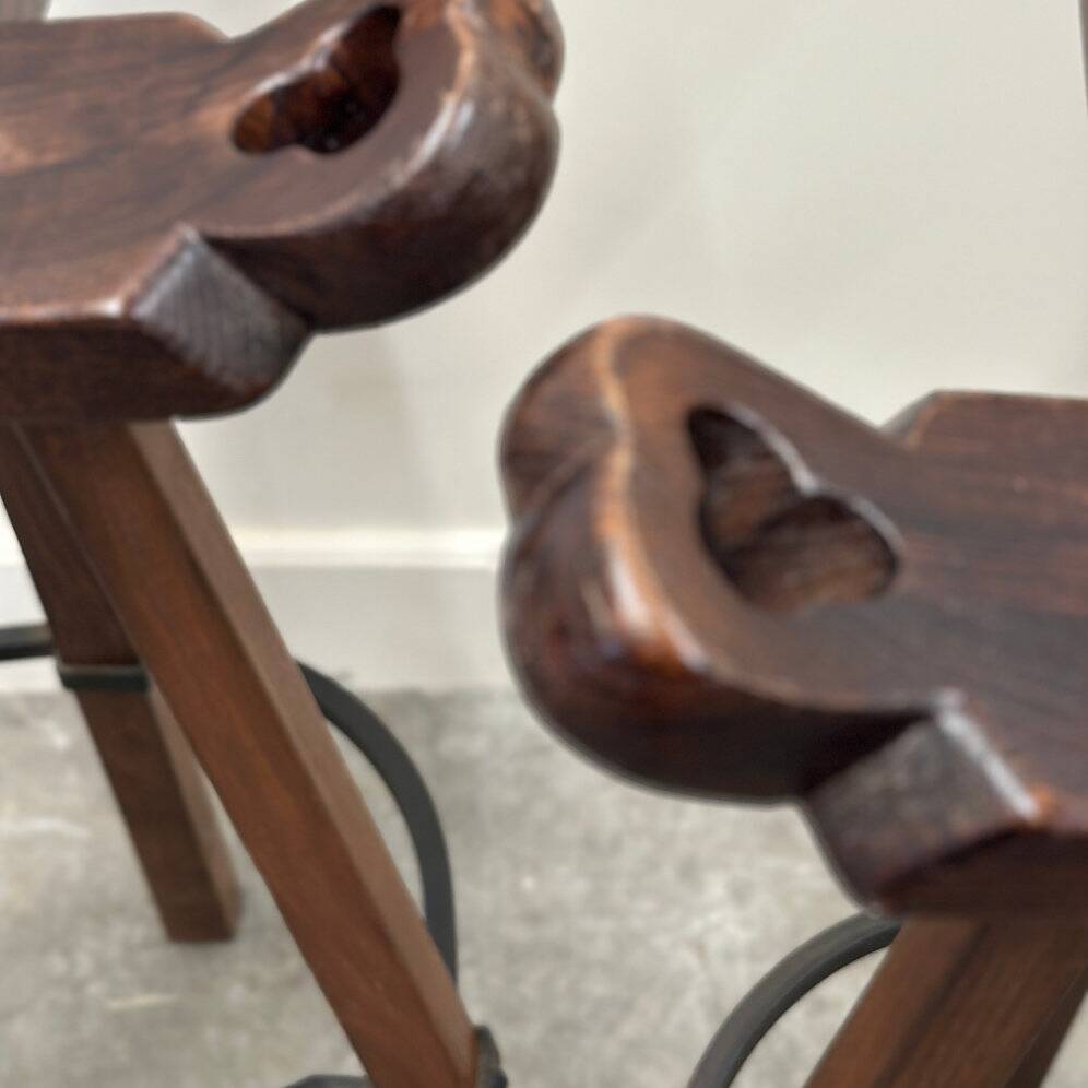 Set of 3 rustic carved oak bar stools with iron footrests, 1970s