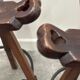Set of 3 rustic carved oak bar stools with iron footrests, 1970s