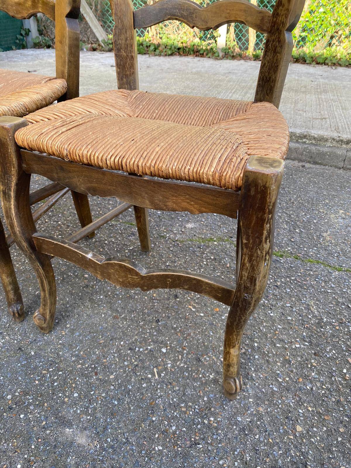 2 solid oak carved and rush-seated chairs in the Louis XV style from the 19th century.