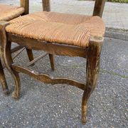 2 solid oak carved and rush-seated chairs in the Louis XV style from the 19th century.
