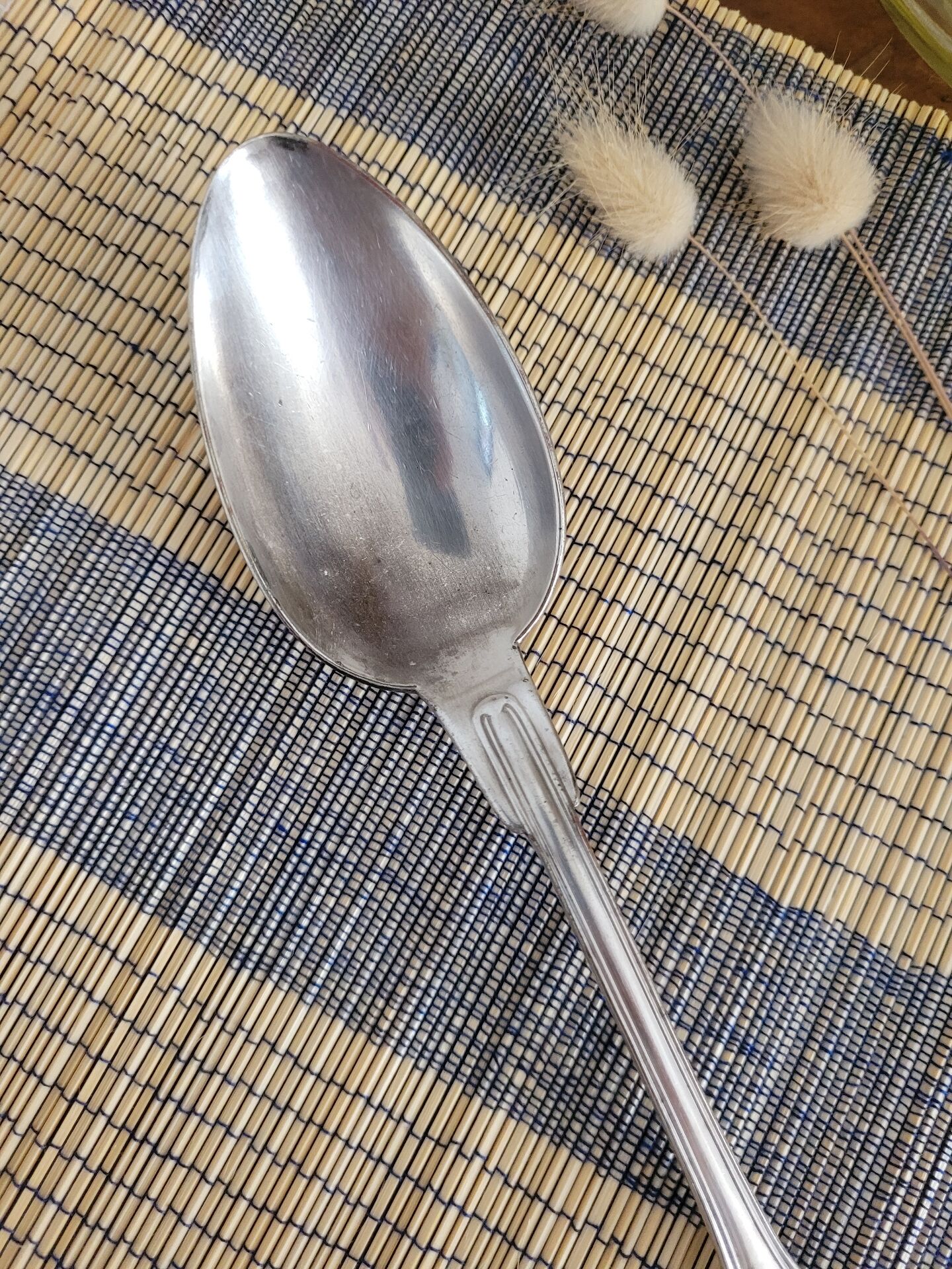 Large silver spoon with net decoration.